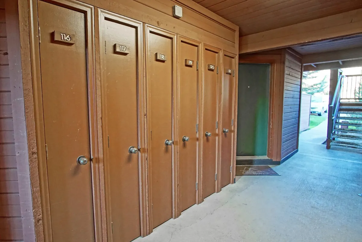 This image presents the property’s entry area, featuring storage lockers, an entrance door, and a staircase. The practical setup and visible organization evoke a sense of arrival and transition, aligning with check-in procedures and the initial guest experience.