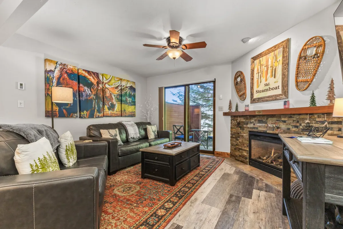 The image showcases a warm and inviting living area with a stylish sofa, modern coffee table, a cozy fireplace as the focal point, and tasteful artwork on the wall. The room exudes comfort and provides an ideal spot for relaxing or gathering with friends and family after a day on the slopes.